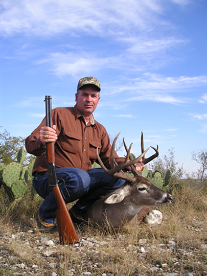 landowner kneeling next to deceased white-tailed deer